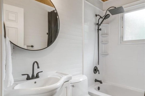 Bathroom with wood ceiling, vanity, toilet, tub, and black fixtures - 2 Adam Lively