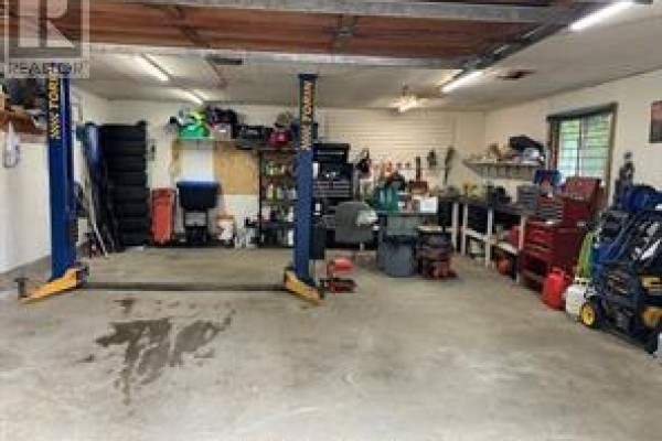 Garage with car lift, workbench, and tool storage - 2 Adam Lively