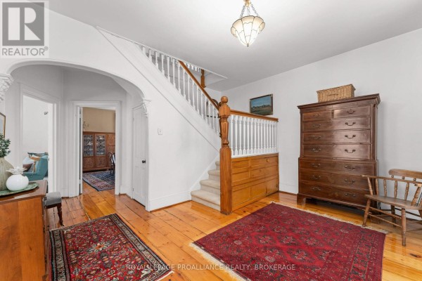 Interior foyer with a staircase, rugs, antique furniture, and an arched doorway. - 2 Alwington Avenue, Kingston