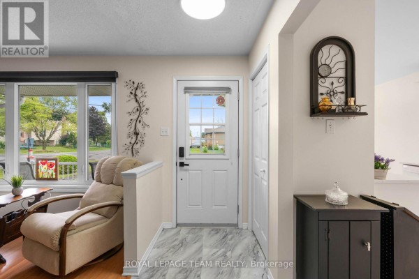 Interior entryway with a recliner, white door, and light beige walls. - 2 Billings Avenue W, South Dundas