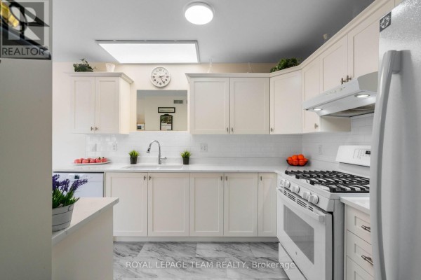 White kitchen cabinets and countertops with a gas stove and white appliances. - 2 Billings Avenue W, South Dundas