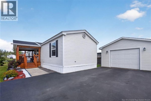 Rear side of the house showing vinyl siding, with the white garage door to the right. - 2 Bur Oak Street, Moncton