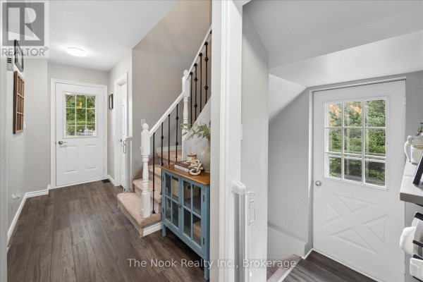 Hallway with white doors, stairs, a console table, and a view of the backyard. - 2 Century Boulevard, Cavan Monaghan