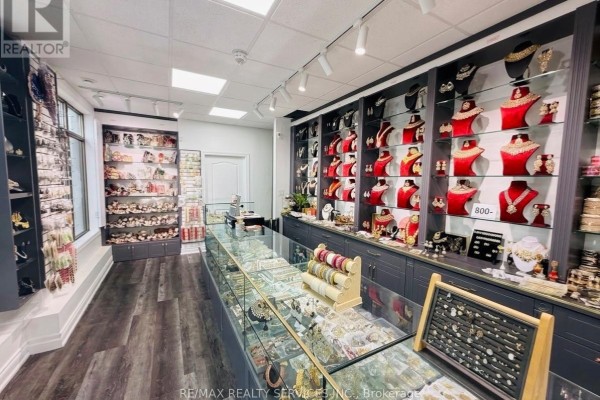 Interior of a jewelry store with glass display cases, shelves of necklaces, and dark gray cabinetry. - 2 Davenfield Circle, Brampton