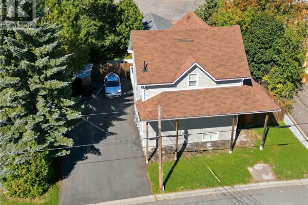 Aerial view of a grey house with a brown roof and driveway, surrounded by trees. - 2 Evans Road, Copper Cliff
