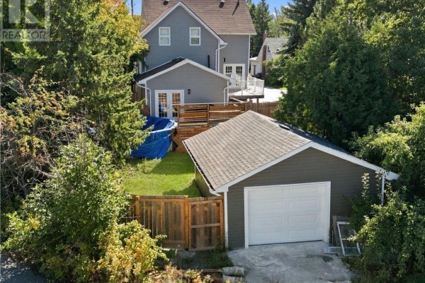 Rear view of the property showing a garage, shed, fenced yard, and a pool cover. - 2 Evans Road, Copper Cliff