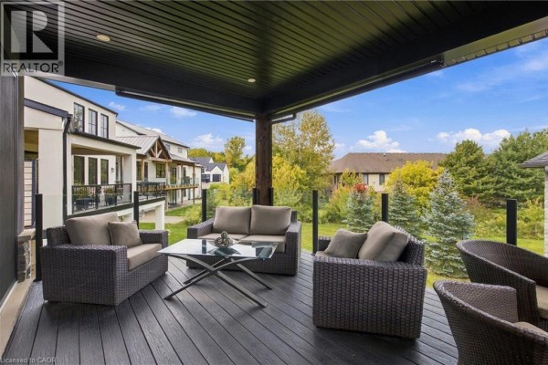 View from the covered deck showing outdoor seating and a landscaped backyard with mature trees and neighboring homes. - 2 Fedorkow Lane, Niagara On The Lake