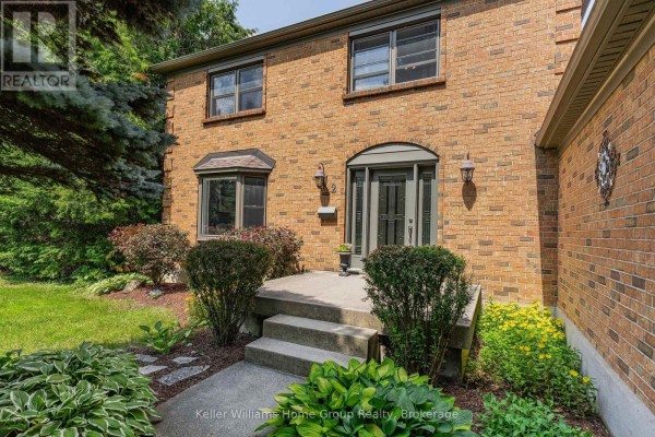 Close-up of the house entrance with stone steps, arched doorway, and flanking shrubs. - 2 Gow Street, Centre Wellington