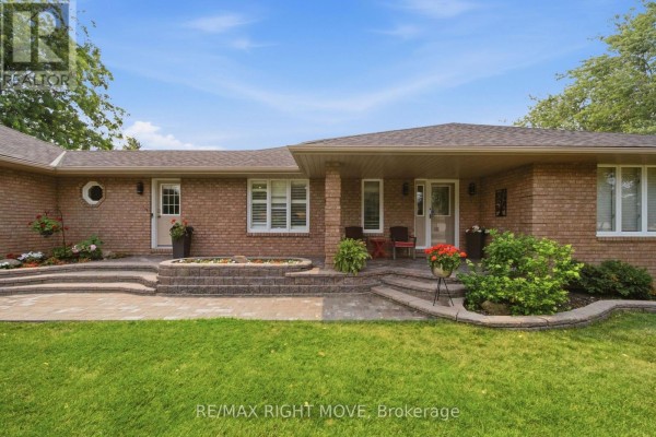 Spacious finished basement with grey sofa, exercise bike, television, brick fireplace, and dining area. - 2 Lavender Court, Ramara