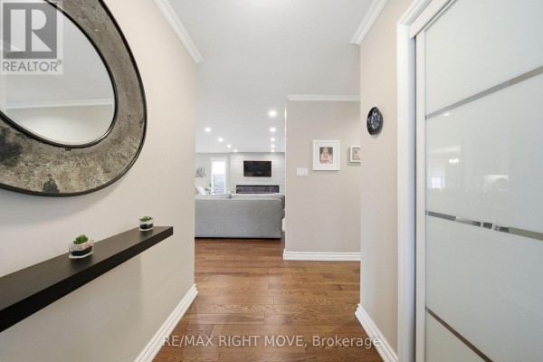 Modern white kitchen with light grey countertops, stainless steel appliances, and island with seating. - 2 Lavender Court, Ramara