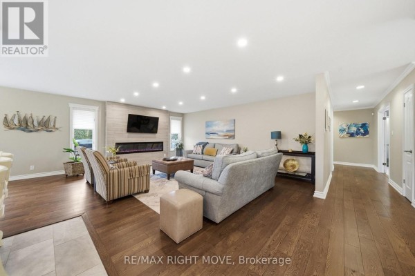 Basement recreation area with dining table, chairs, fireplace, exercise equipment, and stairs to upper level. - 2 Lavender Court, Ramara