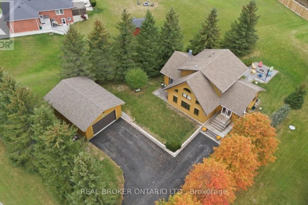 Aerial view of a large wooden house and detached garage surrounded by trees. - 2 Limosano Street, Scugog