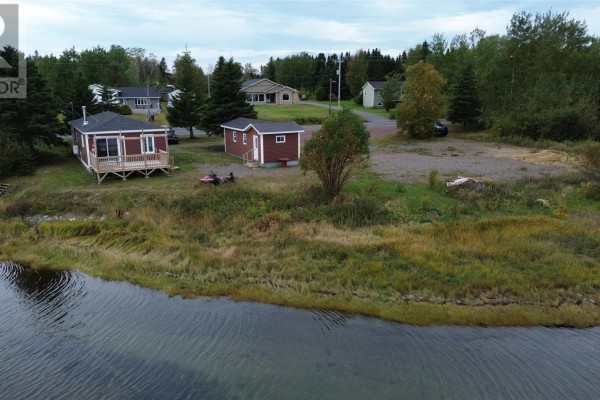 Aerial view of a red house, a detached shed, and surrounding grassy terrain with trees. - 2 Main Street, Northern Arm