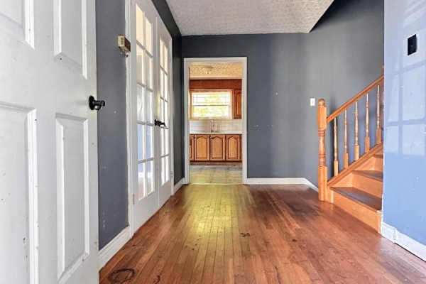 Interior hallway with hardwood floors, dark blue walls, and a view into the kitchen. - 2 Mcmaster Place, Mount Pearl