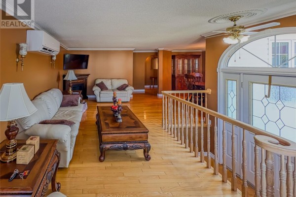 Living room with beige sofas, a dark wood coffee table, and a fireplace. - 2 Millers Avenue, Roberts Arm