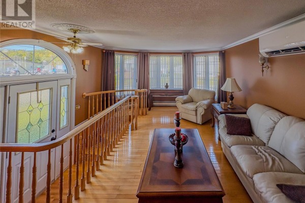 Living room furnished with cream sofas and chairs, overlooking the front entrance and large windows. - 2 Millers Avenue, Roberts Arm