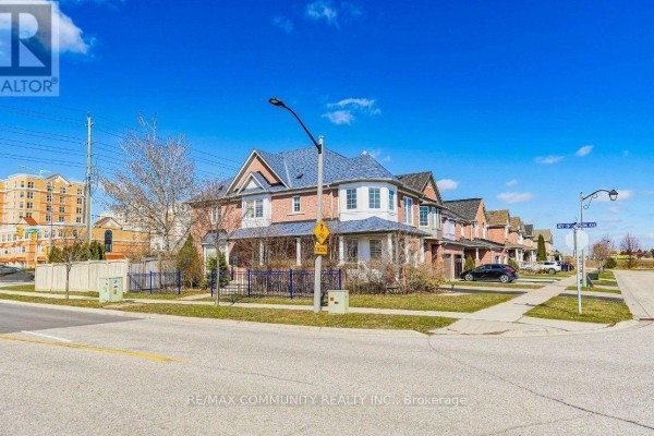Street view of a townhouse complex on a corner lot with a blue fenced yard. - 2 Oglevie Drive, Whitby