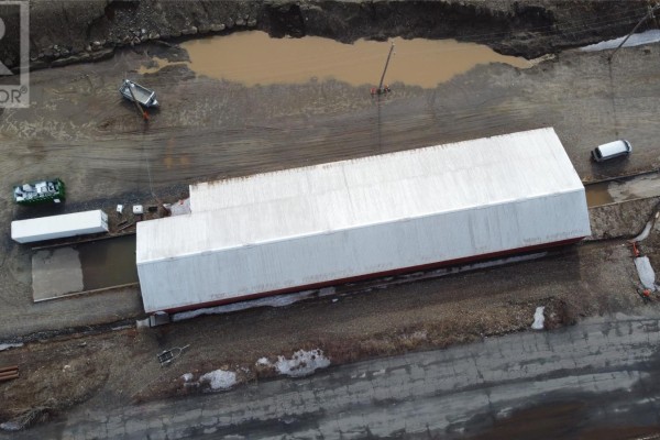 Aerial view of a long red and white industrial building with surrounding dirt and puddles. - 2 Old Industrial Road, Wabush