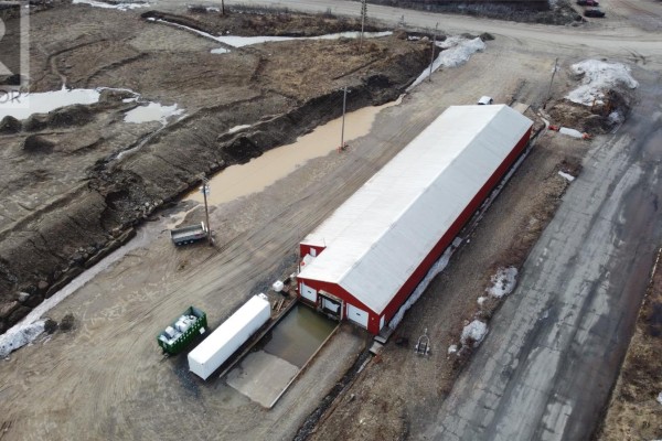 Aerial view of a long red and white industrial building with loading bays and external containers. - 2 Old Industrial Road, Wabush