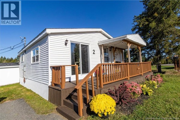 Exterior view of the white house with a sliding glass door, wooden deck, and railings. - 2 Orchard Crescent, Picadilly