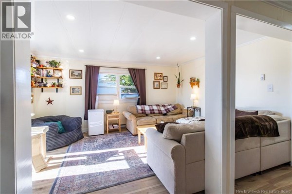 Living room with beige sofas, a patterned rug, a coffee table, and shelves on the wall. - 2 Orchard Crescent, Picadilly