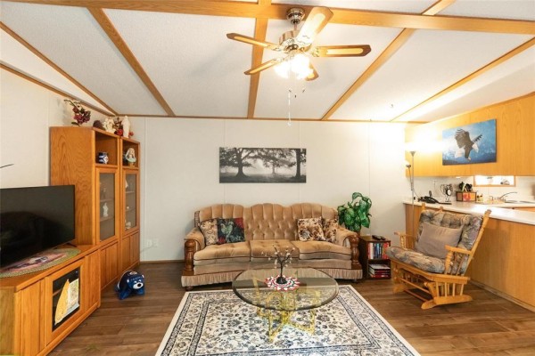 Living room with a sofa, armchair, coffee table, and a television on a stand. - 2 Paradise Drive, Ste Anne