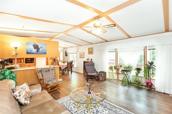 Living room and dining area with light wood cabinets, a dining table, and large windows. - 2 Paradise Drive, Ste Anne
