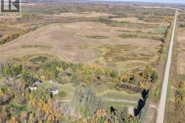 Aerial view of a rural yard site with a house, outbuildings, and trees bordering cultivated fields. - 2 Quarters Mixed Use Land & Yard Site Near Sheho, Foam Lake Rm No  276