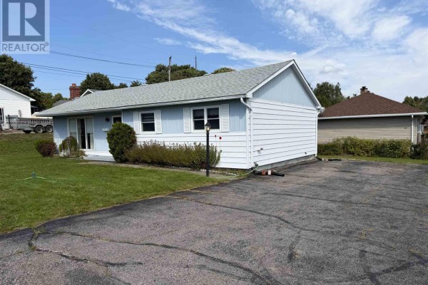 Side exterior of a light blue vinyl-sided bungalow with a paved driveway. - 2 Tecumseh Rd, Elliot Lake