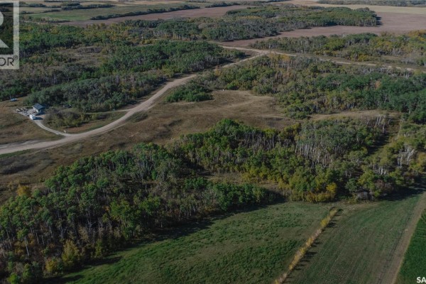 Expansive aerial view of rolling land with a winding dirt road, patches of trees, and agricultural fields. - 2 Whitetail Trail, Duck Lake Rm No  463