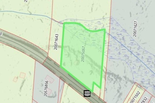Overhead drone view of a large, undeveloped parcel of land with dry grass and trees. - 2.17 Acres Route 355, Sainte Rose