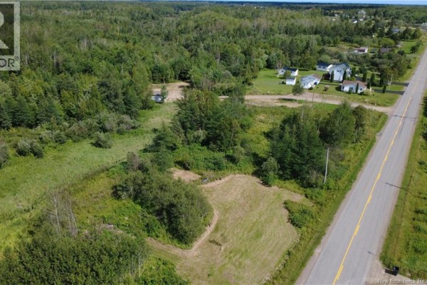 Expansive aerial shot of rural land featuring a road, trees, and a small body of water. - 2.17 Acres Route 355, Sainte Rose