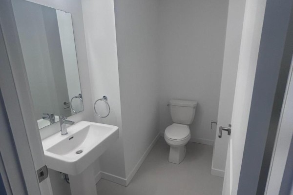 Small powder room with a white pedestal sink, chrome faucet, and toilet against a light gray wall. - 20 - 3175 Denison Street, Markham