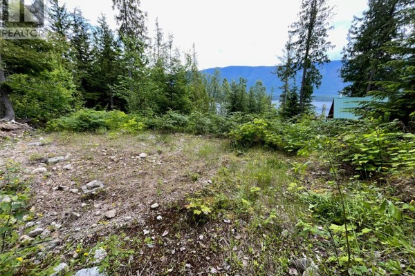 Wooden deck with railings overlooking a forest and lake with stairs leading down. - 20-9000 Seymour Main Lot# 20, Seymour Arm