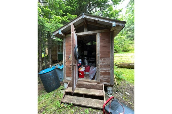 Cleared area of land with scattered rocks and vegetation, surrounded by trees. - 20-9000 Seymour Main Lot# 20, Seymour Arm