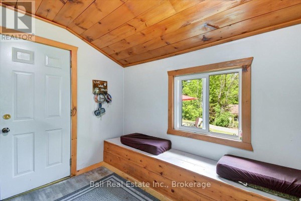 Dining table with four chairs sits in front of a large wooden china cabinet. - 20 Art Bott Road, North Kawartha
