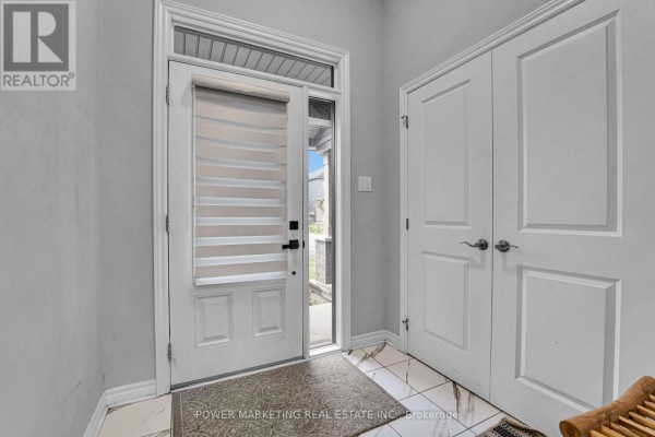 Interior view of the foyer with a white door, beige blinds, white doors, and tiled flooring. - 20 Atop Lane, Ottawa
