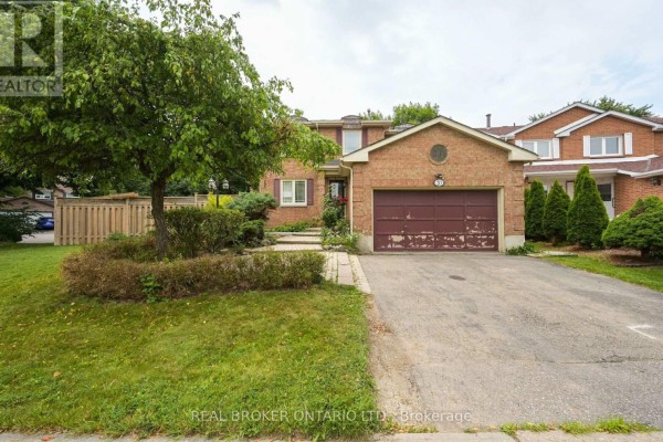 Brick house exterior with a large tree, grass lawn, driveway, and garage. - 20 Campkin Street, Brampton