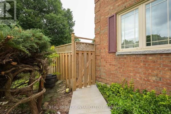 Wooden gate and fence next to a brick wall and a window with red shutters. - 20 Campkin Street, Brampton