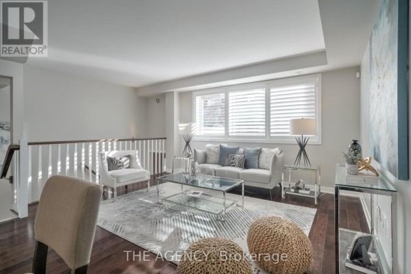 Living area with sofa, coffee table, and framed artwork on the wall. - 20 Cole Street, Toronto