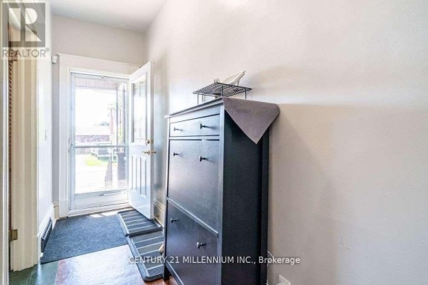 Entryway with a black shoe cabinet, two grey mats, and a glass-paneled door. - 20 Dickson Street, Hamilton