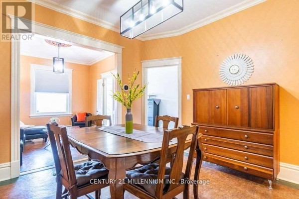 Dining room with a wooden table and chairs, orange walls, and a wooden cabinet. - 20 Dickson Street, Hamilton