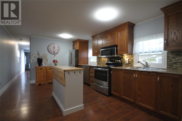 View down hallway from kitchen, with stainless steel appliances and island. - 20 Evergreen Drive, Paradise