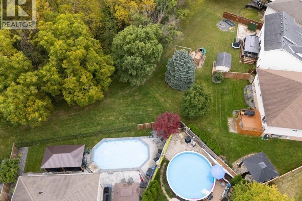 Aerial view of a large backyard with two swimming pools and mature trees. - 20 Goldenrod Court, Chatham