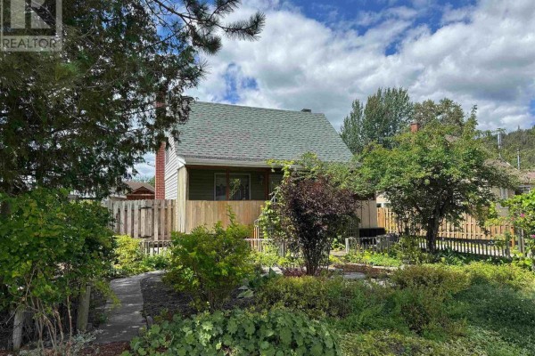 A slightly different angle of the house facade, showcasing the walkway and garden beds. - 20 Heron Drive, Manitouwadge