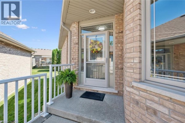Pathway leading to the side of a brick townhouse with air conditioning units. - 20 Isherwood Avenue Unit# 118, Cambridge