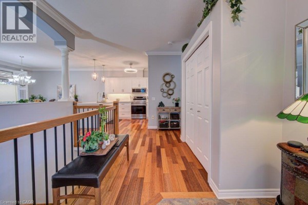 Interior hallway with hardwood floors, staircase, and view into the kitchen. - 20 Isherwood Avenue Unit# 29, Cambridge