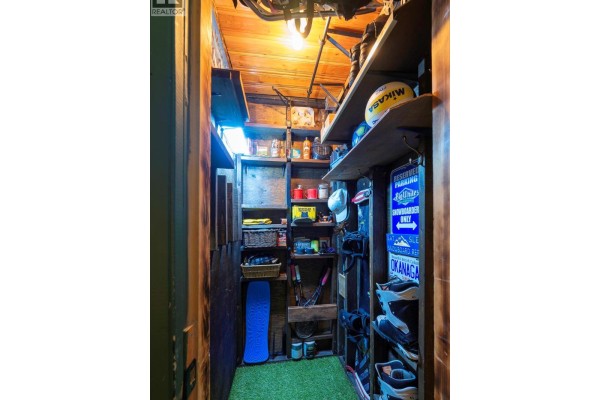 Storage closet with shelves filled with boots, helmets, and other outdoor gear. - 20 Kettleview Road Unit# 305, Big White