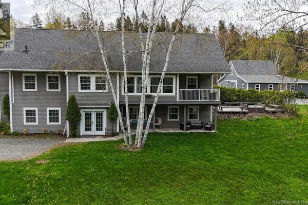Backyard view featuring a patio area, trees, and a two-story home. - 20 Left Branch Salmon Hill Road, Florenceville Bristol