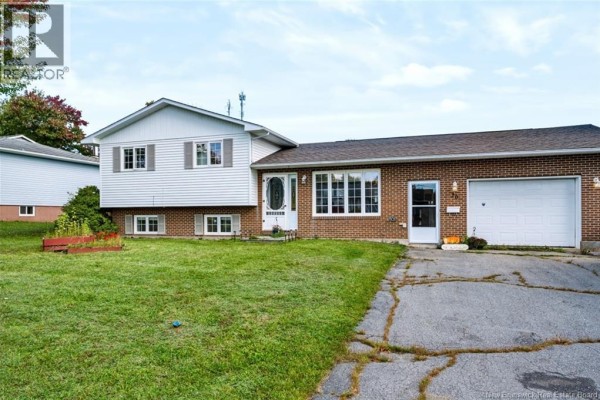 Exterior view of 20 Locke Street, a split-level home with brick and white siding. - 20 Locke Street, Miramichi